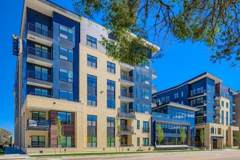 A modern apartment building with blue and beige facades.
