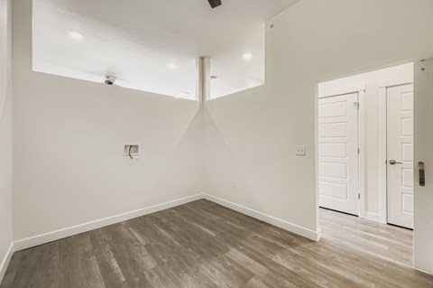 A room with a white door and a light switch on the wall.