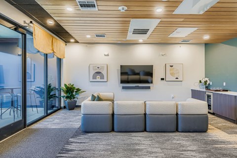 A modern office space with a grey carpet and a wooden ceiling.