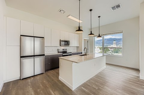 A kitchen with a refrigerator, microwave, and oven.