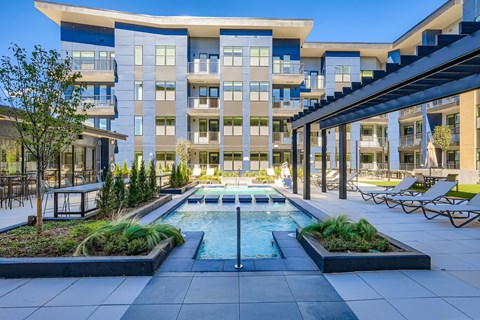 A modern building with a pool in the courtyard.
