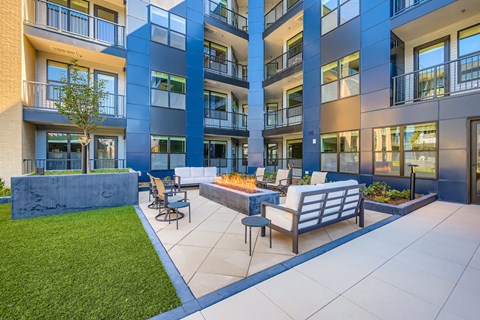 A modern apartment complex with a courtyard and seating area.