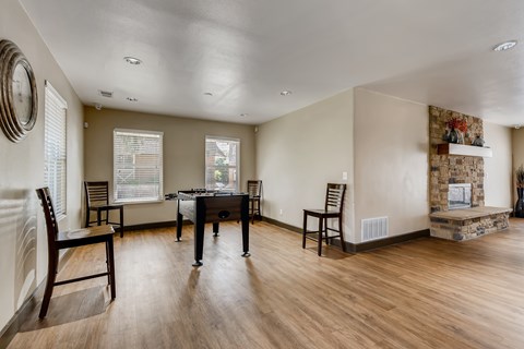 A room with a pool table and chairs.