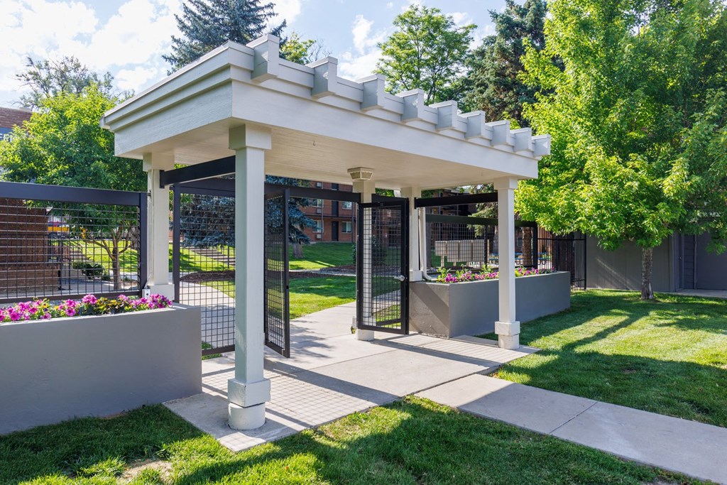 a covered patio with a pergola on a lawn