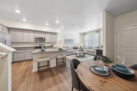 A modern kitchen with a dining table set for two.