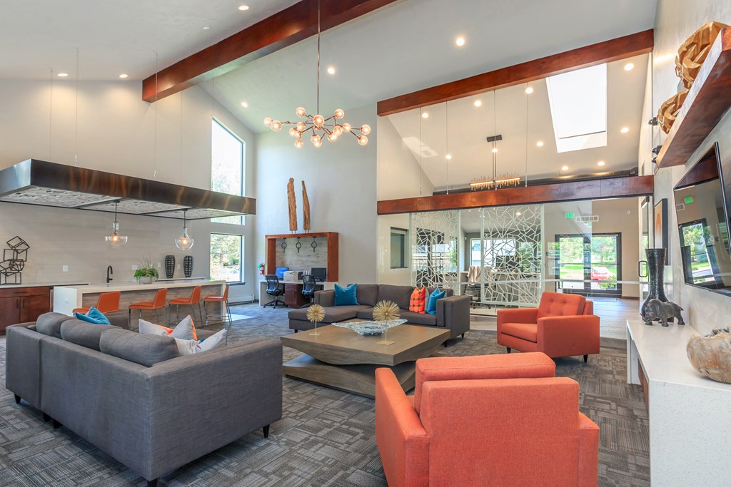 A modern living room with a grey sofa, orange chairs and a wooden coffee table.