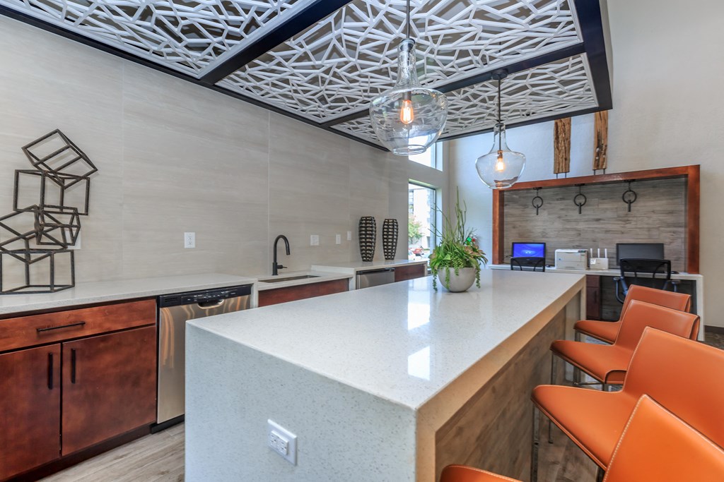 A kitchen with a white countertop and orange chairs.