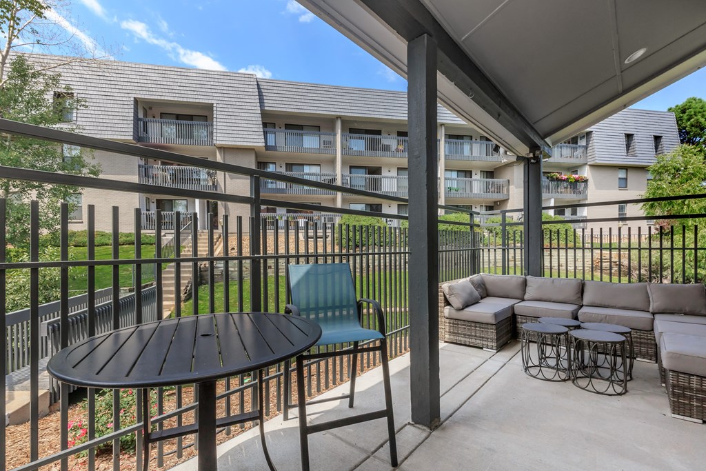A patio with a table and chairs overlooking a building.
