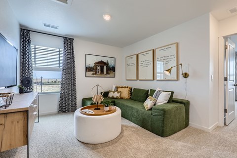 A living room with a green couch and a white coffee table.