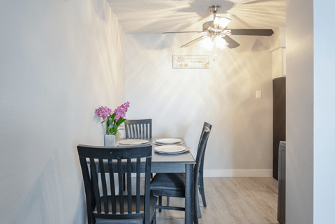 A dining room with a table set for two.