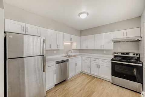 A kitchen with white cabinets and stainless steel appliances.