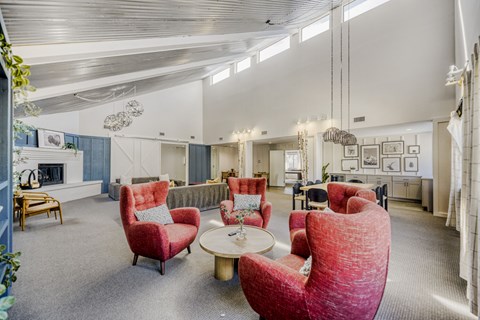 A living room with red chairs and a grey carpet.