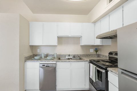 A kitchen with white cabinets and appliances.