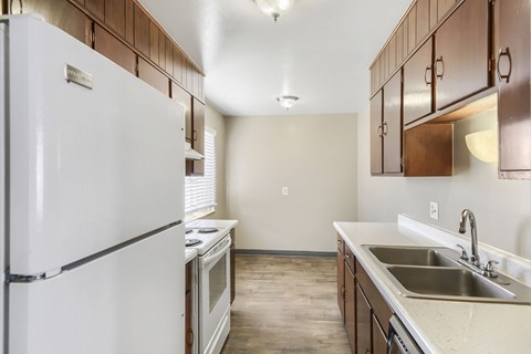 A kitchen with a white refrigerator and wooden cabinets.