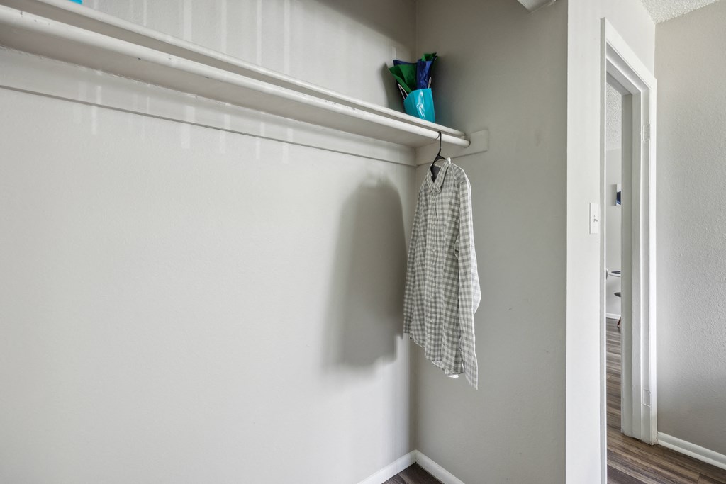an empty closet in a home with a towel hanging on a rack on the wall