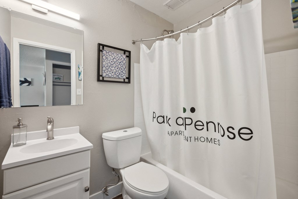 a bathroom with a white shower curtain and a sink and toilet