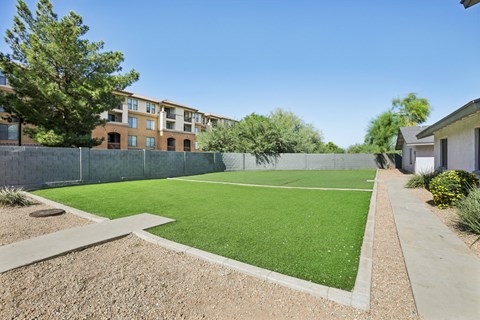 A green lawn in front of apartment buildings.
