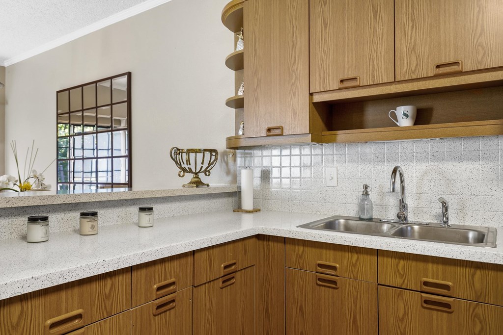 A kitchen with wooden cabinets and a white countertop.