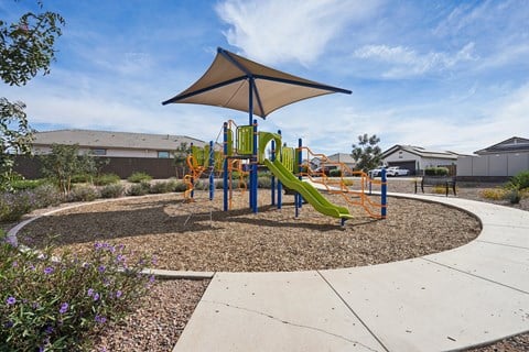 A playground with a yellow slide and a shaded area.