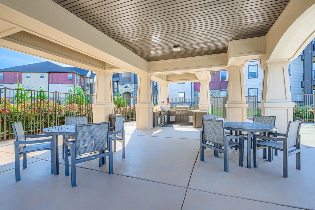 A patio with a table and chairs is surrounded by a fence.