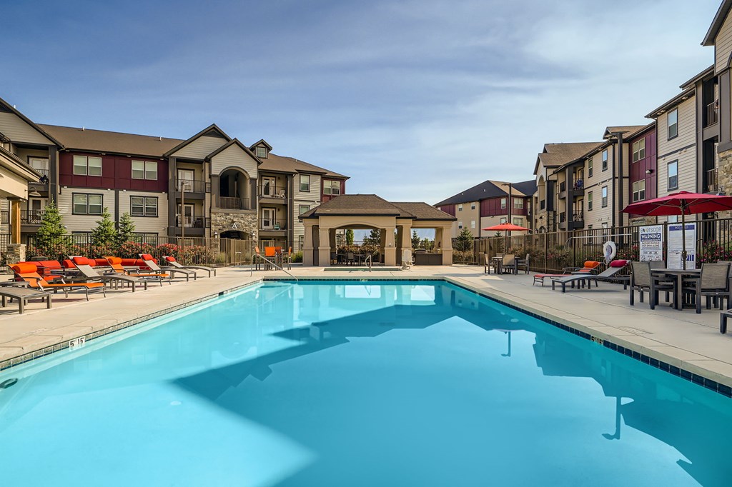 A large swimming pool in front of apartment buildings.