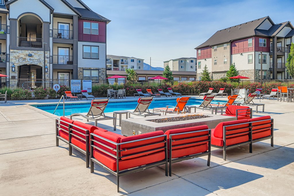 A pool area with red chairs and a pool table.