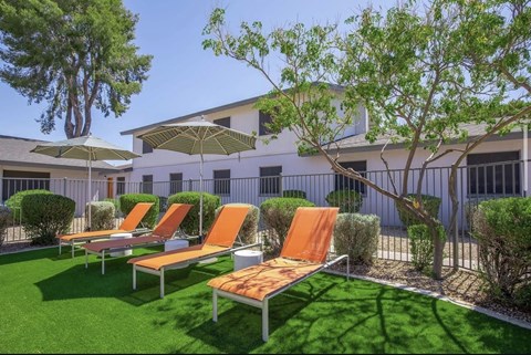 A sunny day at the outdoor seating area with orange chairs and umbrellas.