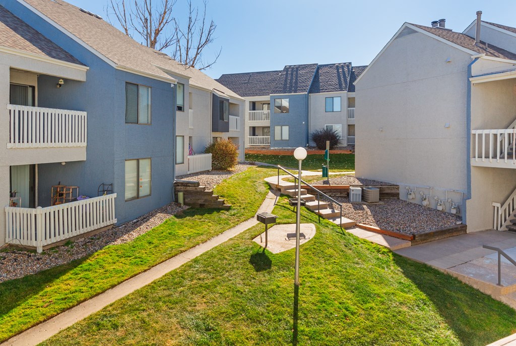 a view of the backyard of an apartment building with a yard and grass