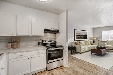 A modern kitchen with white cabinets and a stainless steel oven.