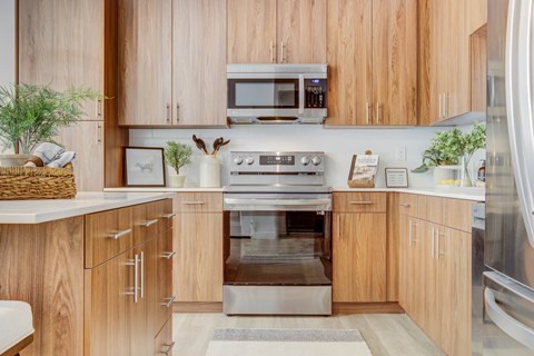 A modern kitchen with wooden cabinets and stainless steel appliances.
