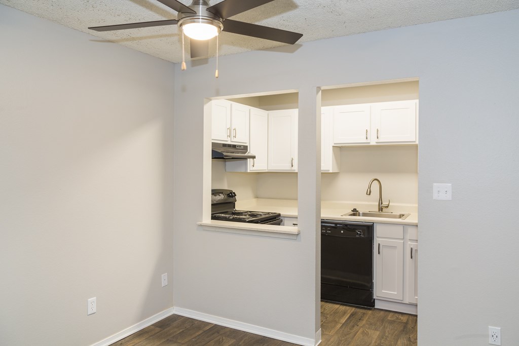 A kitchen with a fan on the ceiling and a dishwasher.