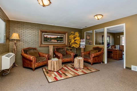 A living room with brown leather chairs and a painting on the wall.
