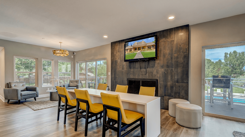a dining room with a table and chairs and a tv on the wall