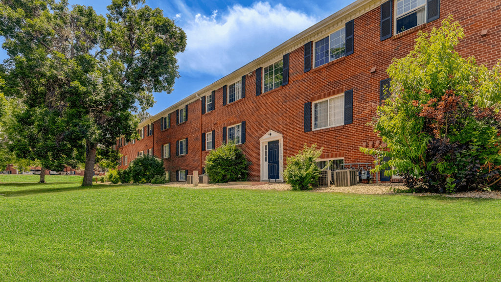 a large brick building with green grass in front of it