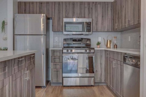 A modern kitchen with a stainless steel refrigerator and oven.