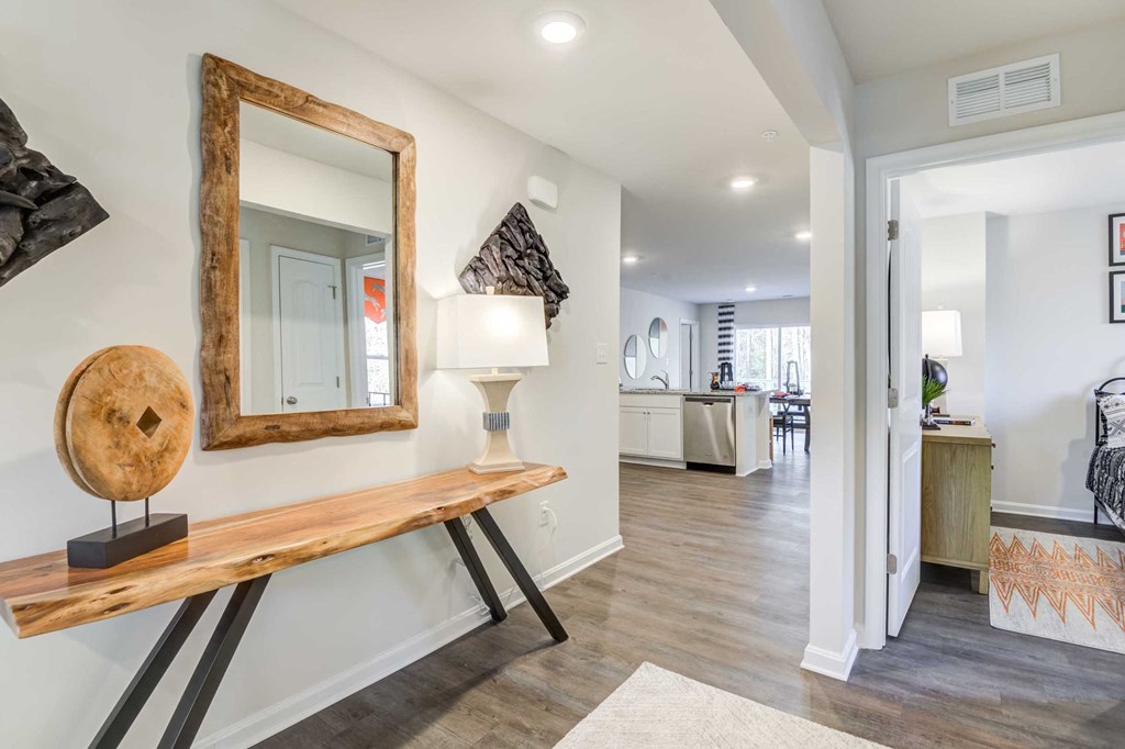 a living room with a wooden table and a mirror