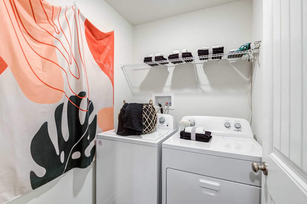 a white laundry room with two washers and a sink