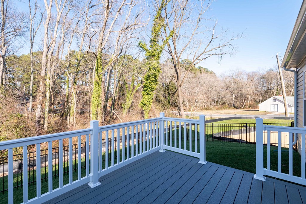 a deck with a view of a yard and trees