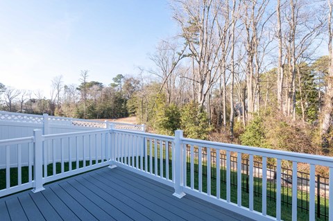 a deck with a view of a yard and trees