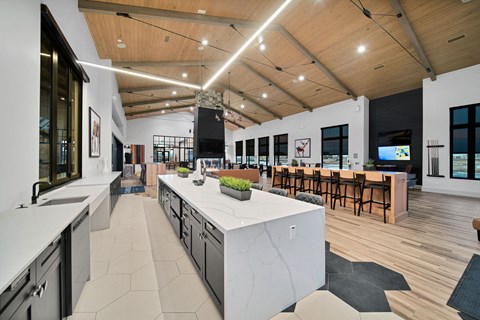 a large kitchen with a large island and a dining room with a table and chairs
