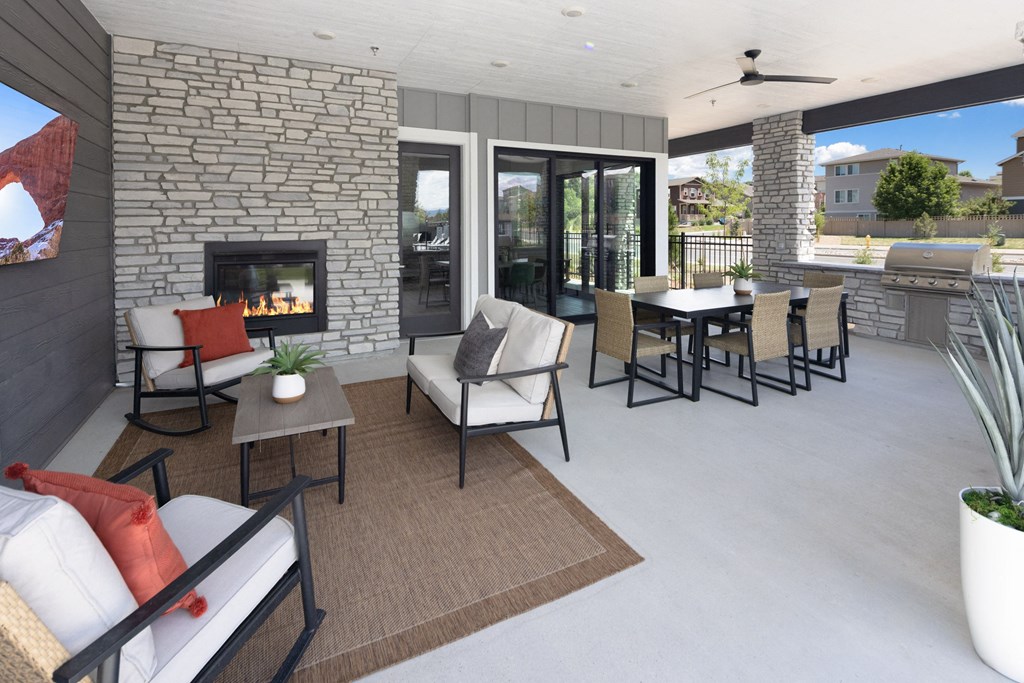 a patio with a fireplace and chairs and tables