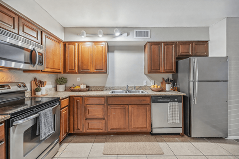 A kitchen with wooden cabinets and stainless steel appliances.