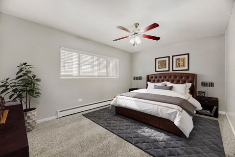 A bedroom with a large bed and a ceiling fan.