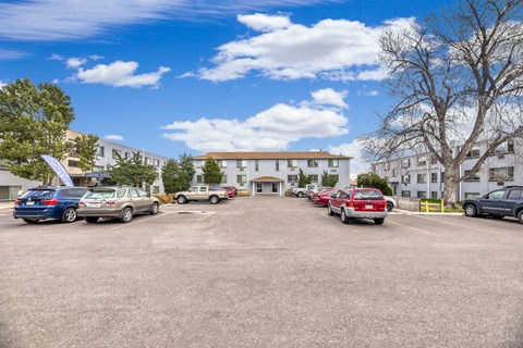 A parking lot with cars and a building in the background.