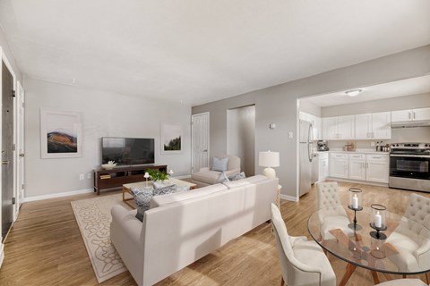 A modern living room with a white couch and a glass table.