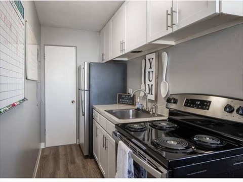 A kitchen with a stove top oven and a refrigerator.