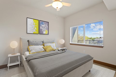 A bedroom with a large bed and a ceiling fan.