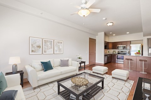 A living room with a white couch and a glass coffee table.