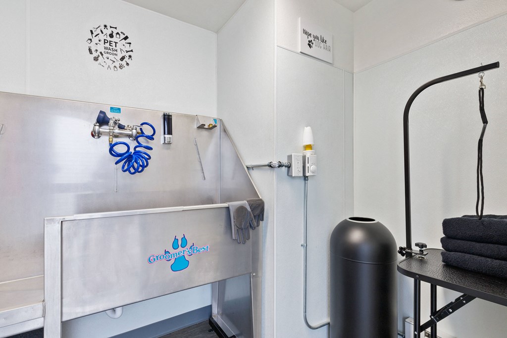 a small laundry room with a sink and a ironing board