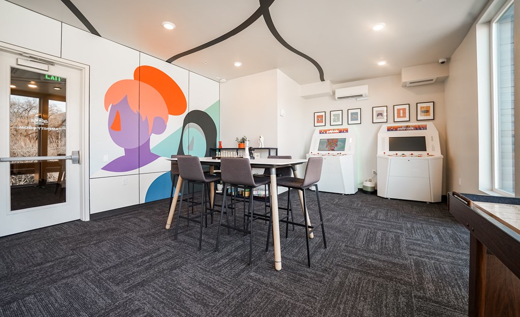 a dining room with a table and chairs and a refrigerator and a sink